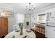 Bright dining room with a round table, modern chandelier and a view into the kitchen at 701 14Th N St, St Petersburg, FL 33705