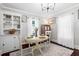 Cozy dining room with a modern chandelier, built-in shelving, and a bright window with white trim at 701 14Th N St, St Petersburg, FL 33705