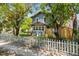 Charming two-story home with mature trees and a white picket fence along the sidewalk at 701 14Th N St, St Petersburg, FL 33705