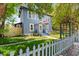 Charming blue two-story home with a well-manicured lawn, picket fence, and lush landscaping at 701 14Th N St, St Petersburg, FL 33705