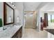 Bright bathroom featuring double sinks, granite countertops, a stone shower and neutral paint at 706 S Davis Blvd, Tampa, FL 33606