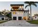 Modern three-story home featuring a private balcony, two-car garage, and a paver driveway at 706 S Davis Blvd, Tampa, FL 33606