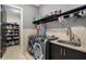 Laundry room with front-loading washer and dryer, granite counters, cabinetry, and shelving at 706 S Davis Blvd, Tampa, FL 33606