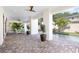 Covered outdoor living space featuring a patterned brick floor, potted plants, and view to the pool at 706 S Davis Blvd, Tampa, FL 33606
