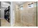 Walk-in shower featuring a glass enclosure, stone tile, and a dual shower head at 706 S Davis Blvd, Tampa, FL 33606