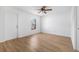 Bright bedroom featuring wood-look floors, a ceiling fan, a window, and a white door at 718 30Th N Ave, St Petersburg, FL 33704