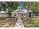 Charming single-story home with a welcoming front porch and a well-maintained yard surrounded by mature trees at 718 30Th N Ave, St Petersburg, FL 33704