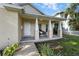 Charming front porch and entry featuring white pillars and a black bench at 718 30Th N Ave, St Petersburg, FL 33704