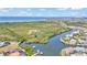 An aerial view of waterfront homes, canals, and lush landscape with ocean in the distance at 729 Manns Harbor Drive, Apollo Beach, FL 33572