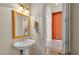 Traditional bathroom with a pedestal sink and an orange accent wall in the hallway at 729 Manns Harbor Drive, Apollo Beach, FL 33572