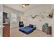 Cozy bedroom boasts carpet, coastal wall art, ceiling fan and lots of natural light at 729 Manns Harbor Drive, Apollo Beach, FL 33572