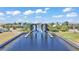 View of boat lift on waterfront canal with lush landscaping and houses in the background at 729 Manns Harbor Drive, Apollo Beach, FL 33572