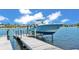 A boat is docked on a lift in the water with a small dock and blue skies at 729 Manns Harbor Drive, Apollo Beach, FL 33572