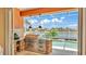 Outdoor kitchen featuring a stainless steel grill and granite countertops with a view of the pool and canal at 729 Manns Harbor Drive, Apollo Beach, FL 33572