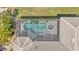 Aerial view of screened-in pool and spa, surrounded by lush tropical landscape and patio at 729 Manns Harbor Drive, Apollo Beach, FL 33572