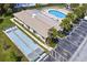 Community featuring shuffleboard courts, outdoor pool, mature trees, and ample parking for residents and guests at 834 Cambridge Ct, Dunedin, FL 34698