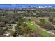 Aerial view showcases proximity to a golf course, highlighting nearby waterfront and residential areas at 834 Cambridge Ct, Dunedin, FL 34698