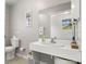 Modern community bathroom features a clean white sink, mirror, toilet, and a small landscape painting at 834 Cambridge Ct, Dunedin, FL 34698