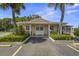 Picturesque clubhouse with double doors, white columns, lush landscaping, and convenient parking at 834 Cambridge Ct, Dunedin, FL 34698