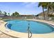 Inviting community pool with palm trees and lounge chairs, perfect for relaxation and recreation at 834 Cambridge Ct, Dunedin, FL 34698
