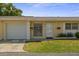 Charming single-story home featuring an attached garage, well-maintained lawn, and inviting front door at 834 Cambridge Ct, Dunedin, FL 34698