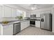 Bright kitchen featuring stainless steel appliances, white cabinetry, and lots of counter space at 834 Cambridge Ct, Dunedin, FL 34698