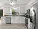 Bright kitchen with stainless steel appliances, white cabinetry, and a window view at 834 Cambridge Ct, Dunedin, FL 34698