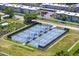 Aerial view of many blue and green Pickleball courts with shade covers near a residential community at 834 Cambridge Ct, Dunedin, FL 34698