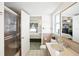 A bathroom with a shower stall, toilet, sink, and a window with a view of the bedroom at 8413 Moulton Dr, Port Richey, FL 34668