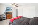 Bright bedroom features a ceiling fan, closet, and televisions above a dresser at 8413 Moulton Dr, Port Richey, FL 34668