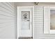Close-up of the front door, enhanced by a decorative wreath and sidelight window at 8413 Moulton Dr, Port Richey, FL 34668