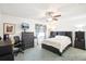The main bedroom has a ceiling fan and is furnished with a bed, dresser, and a bookcase at 8413 Moulton Dr, Port Richey, FL 34668