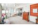 Bright sunroom with large sliding glass doors, ceiling fan, and wood dresser at 8413 Moulton Dr, Port Richey, FL 34668