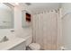 Functional bathroom with a gray vanity, a toilet, and a shower with patterned curtain at 9206 Wood Lake Blvd, Tampa, FL 33615