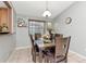 Inviting dining room with a dark wood table set for six, featuring a modern light fixture and neutral decor at 9206 Wood Lake Blvd, Tampa, FL 33615