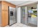Bright kitchen with stainless steel refrigerator and sliding glass doors leading to the outdoor patio at 9206 Wood Lake Blvd, Tampa, FL 33615