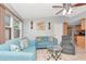 Bright living room featuring tile floors, light blue couches, and a modern ceiling fan at 9206 Wood Lake Blvd, Tampa, FL 33615