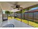 Outdoor screened-in patio shows ceiling fan and nice view of green backyard that enhances the outdoor living space at 9206 Wood Lake Blvd, Tampa, FL 33615