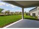 Covered patio offering a view of the manicured backyard and a lush green lawn at 9757 Crescent Moon Dr, Riverview, FL 33578