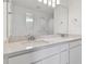 Bathroom featuring quartz countertops, double sinks, and a large mirror at 9765 Crescent Moon Dr, Riverview, FL 33578