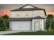 Charming two-story home with a two-car garage and covered entry offers a welcoming facade and tropical landscaping at 9765 Crescent Moon Dr, Riverview, FL 33578