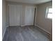 Bedroom with new flooring, window, and double closet at 9825 41St N St, Pinellas Park, FL 33782