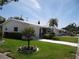 Well-maintained single-story home with a green lawn and mature landscaping on a sunny day at 9825 41St N St, Pinellas Park, FL 33782