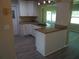 Open floorplan showcasing the kitchen with granite countertops and updated white cabinetry at 9825 41St N St, Pinellas Park, FL 33782
