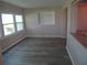 Bright living room featuring stylish gray wood floors, a built-in shelf, and large windows at 9825 41St N St, Pinellas Park, FL 33782