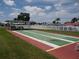 Exterior view of the shuffleboard courts with shaded seating surrounded by lush grass at 9825 41St N St, Pinellas Park, FL 33782