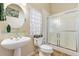 Bright bathroom with pedestal sink, framed art and stand-up shower with sliding glass doors at 1004 Hollyberry Ct, Brandon, FL 33511