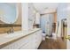 Bright bathroom featuring double sinks, white cabinetry, and a shower with blue curtains at 1004 Hollyberry Ct, Brandon, FL 33511