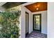 Inviting front entryway with brick flooring, lush greenery, and a charming wood plank ceiling at 1004 Hollyberry Ct, Brandon, FL 33511