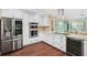 Bright kitchen with stainless steel appliances, granite counters, white cabinets, and hardwood floors at 1004 Hollyberry Ct, Brandon, FL 33511
